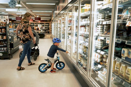 Mother with child in supermarket's cooling section