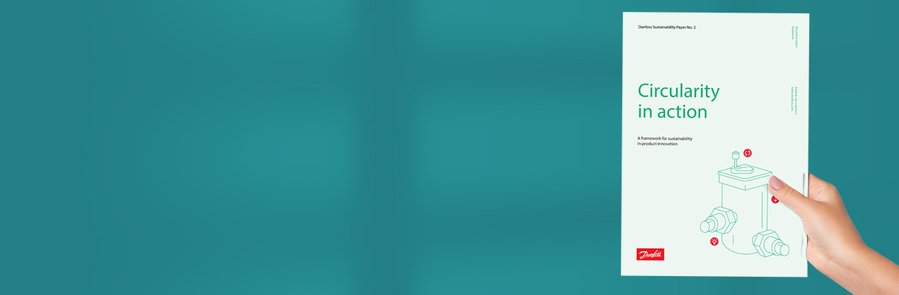 Image of a hand holding a Danfoss sustainability whitepaper with the heading: "Circularity in action"