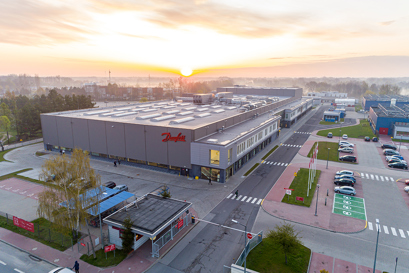 The factory seen from afar with a sunrise in the back