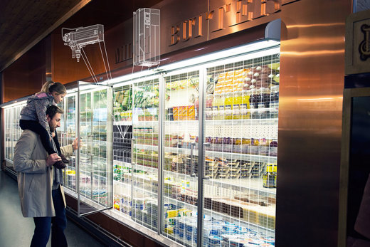 A father holding his young daughter on his shoulders while perusing a supermarket display case