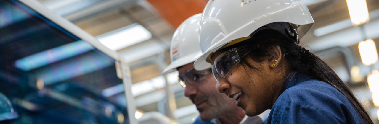2 people wearing hardhats, visiting a Danfoss factory