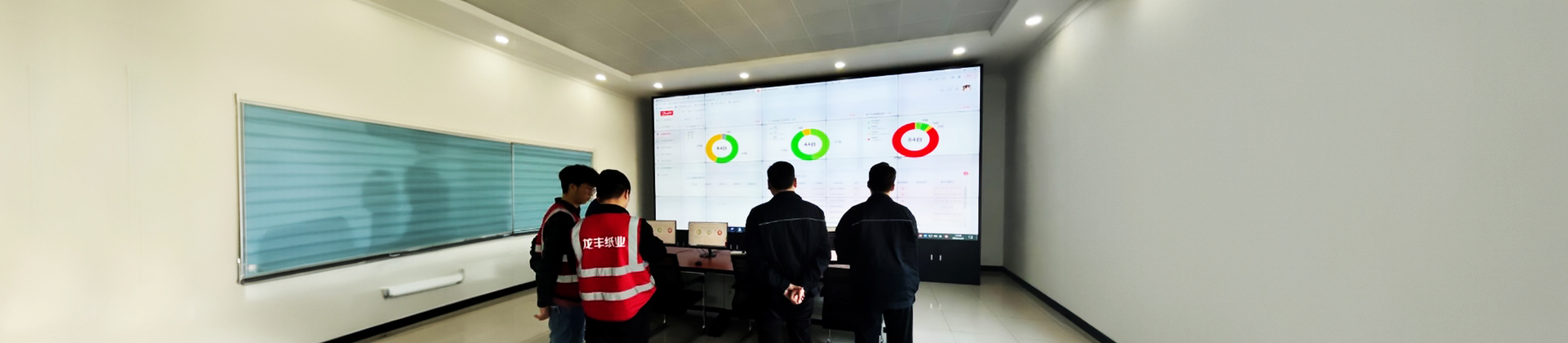 Engineers from Dahe Paper Group talking and looking at their custom dashboard built by Danfoss